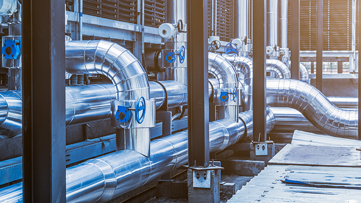 Komplexes Rohrsystem in industrieller Umgebung, symbolisiert technische Gebäudeausrüstung.