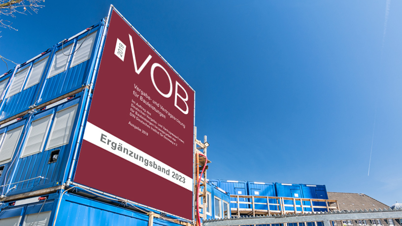 Großes VOB Ergänzungsband 2023 Plakat an einer Baustelle mit blauen Containern