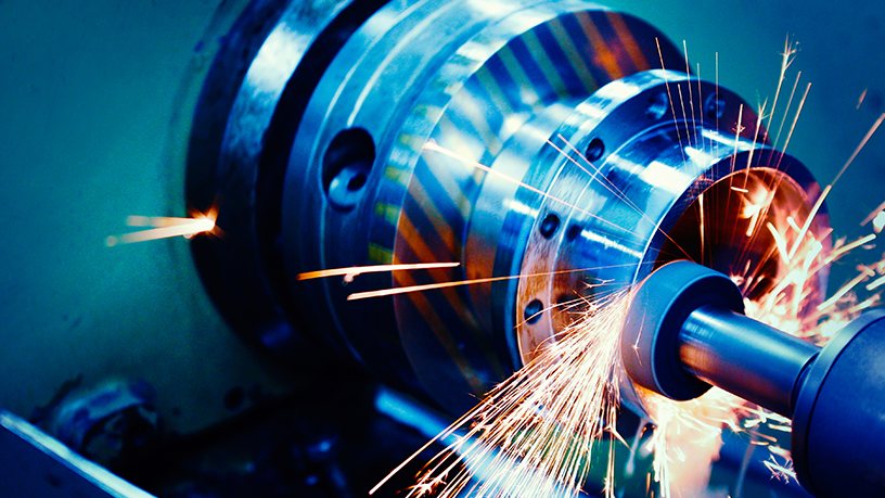 Funken sprühen beim Drehen eines Metallstücks auf einer Drehmaschine.