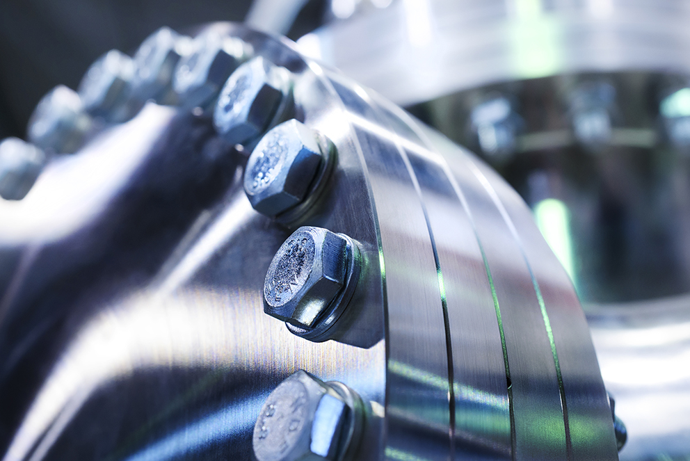 Nahaufnahme einer Metalloberfläche mit mehreren Schrauben und Muttern.