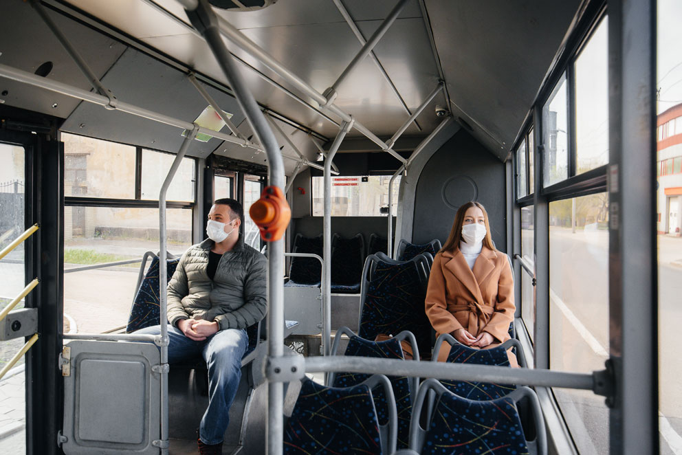 Innenraum eines Busses mit Menschen auf den Sitzen, Blick nach draußen durch die Fenster.