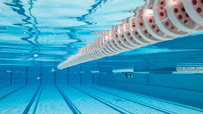 Unterwasseraufnahme einer Schwimmbahn in einem Pool mit einer rot-weißen Trennleine.