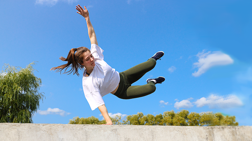 Person führt Parkour-Übung an einer Mauer aus.