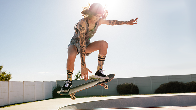 Person macht Skateboard-Trick in einem Skatepark.