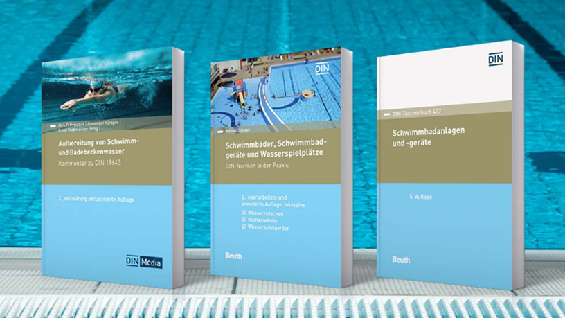 Drei Bücher über Normen für Schwimmbäder und deren Ausstattung vor einem Pool.