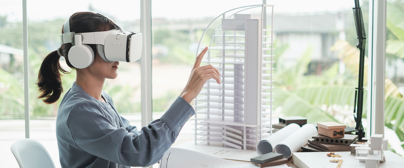 Person nutzt VR-Brille und zeigt auf Architekturmodell.