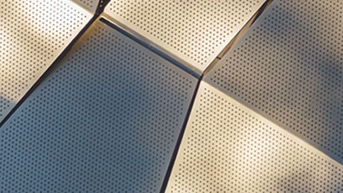 Geometrische, perforierte Metallpanels in der Sonne.