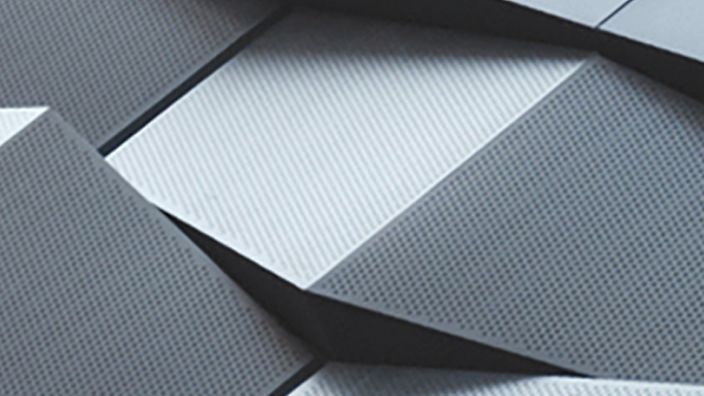 Geometrische, graue Metallplatten mit Struktur.