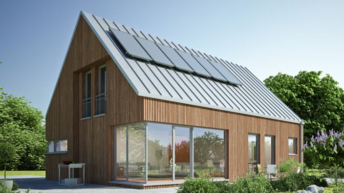 Modernes Holzhaus mit Solarpanelen auf dem Dach, umgeben von grünen Bäumen und Garten unter blauem Himmel.