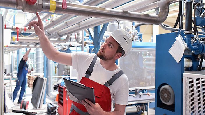 Industrie Zertifizierung - Arbeiter kontrolliert Industrieanlage